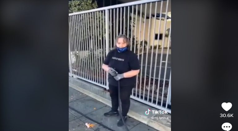 White woman sprays Black homeless people with water hose