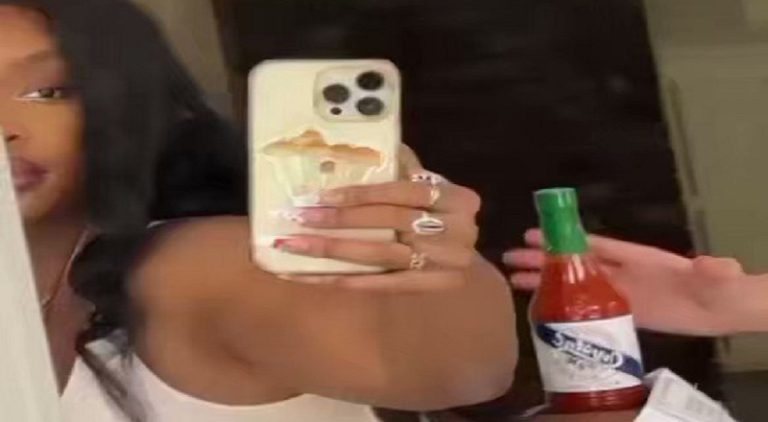 SZA balances a bottle of hot sauce on her bottom