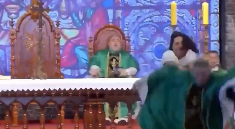 Woman shoves priest off stage in the middle of him preaching