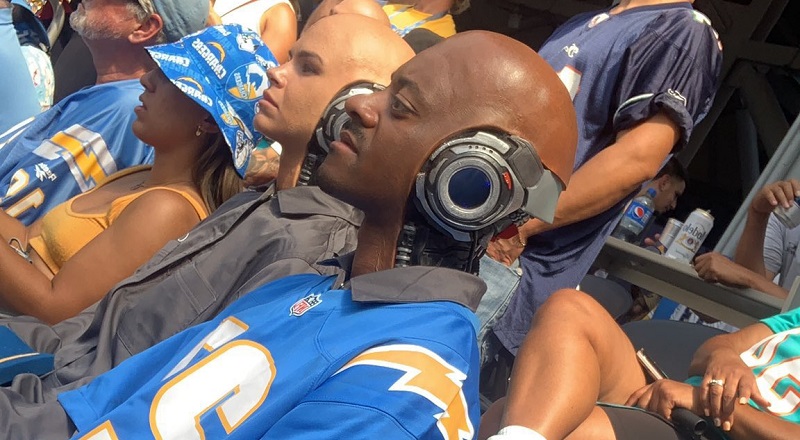 Man sits beside robot couple during LA Chargers game