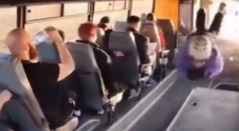 Man drinks water as man crashes through bus window
